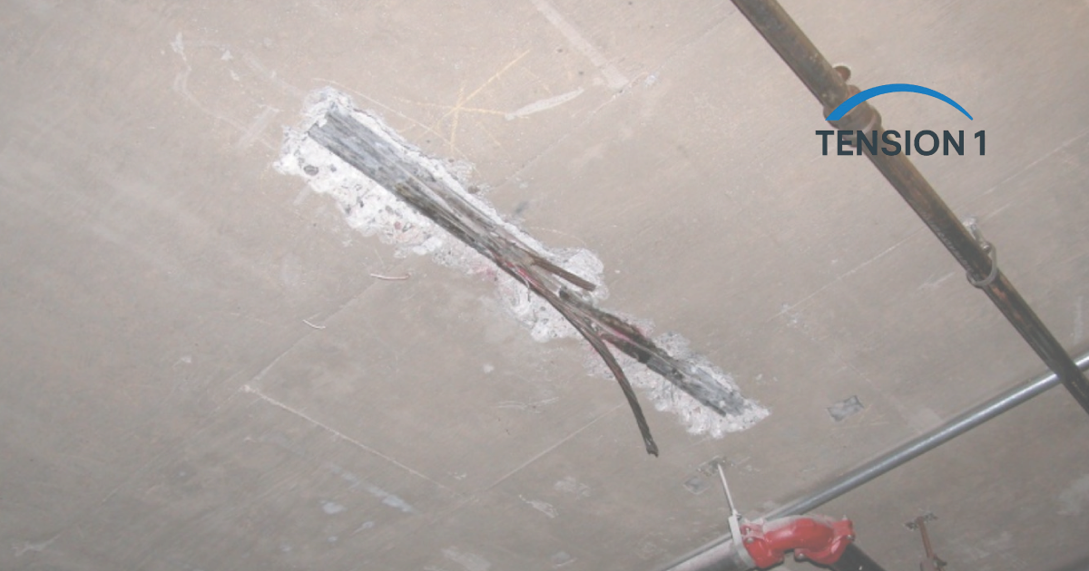 Severe corrosion and structural failure of unbonded tendons exposed through spalled concrete on the underside of a post tension slab.